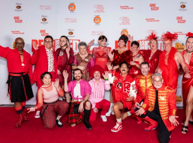 group of people wearing all red outfits posing on a red carpet