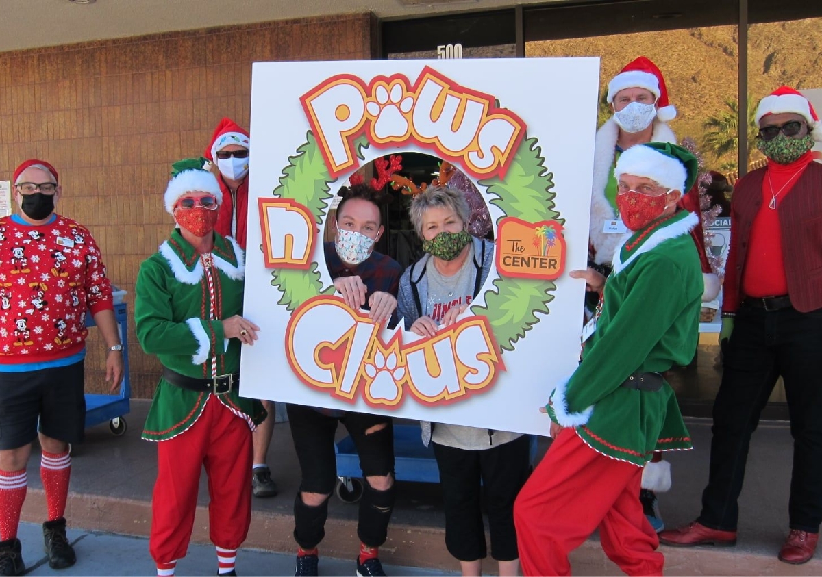 group of people dressed in festive Christmas outfits holding sign