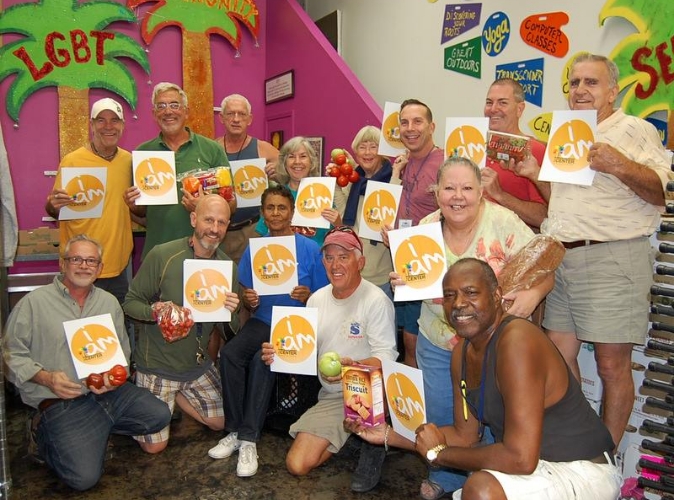 group of people holding an orange sign smiling