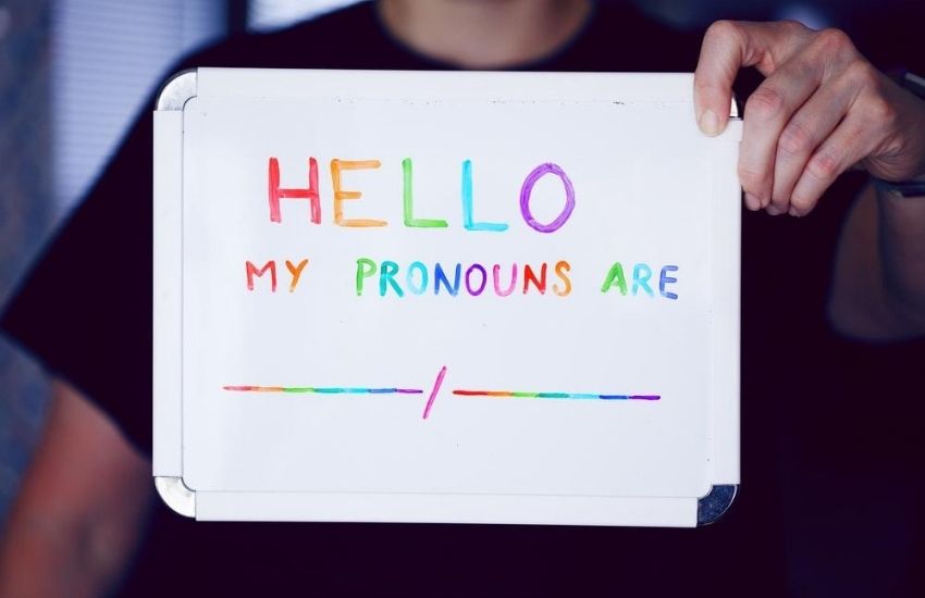 person holding a sign that states hello my pronouns are